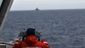 A Coast Guard Cutter Kimball crew-member observes a foreign vessel in the Bering Sea, on Sept. 19, 2022. (U.S. Coast Guard District 17 via AP)