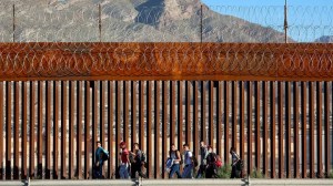 Venezuelan migrants walk along the U.S. Border fence after crossing the Rio Grande from Mexico to turn themselves in to the U.S. Border Patrol on Sept. 22, 2022 in El Paso, Texas.(Joe Raedle/Getty Images)
