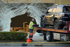 A worker secures a damaged SUV to a flatbed tow truck outside an Apple store in Hingham, Mass., on Nov. 21, 2022. (Steven Senne/AP Photo)