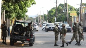 Members of security forces guard the streets as Jamaican Prime Minister Andrew Holness on Tuesday declared a state of public emergency in parts of the capital Kingston, and in some parishes in the central and western parts of the country (Reuters/Gilbert Bellamy)