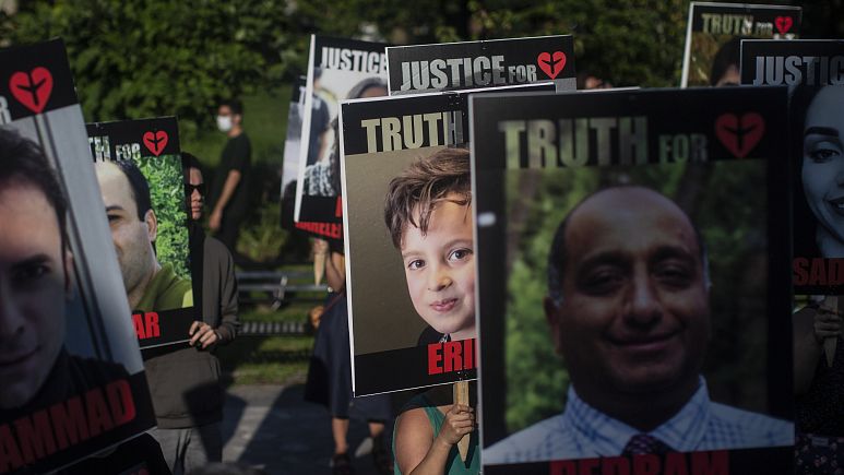 Placards bearing the faces of the victims of Flight PS752 are carried in Toronto.   -   Copyright  Chris Young/The Canadian Press via AP, File