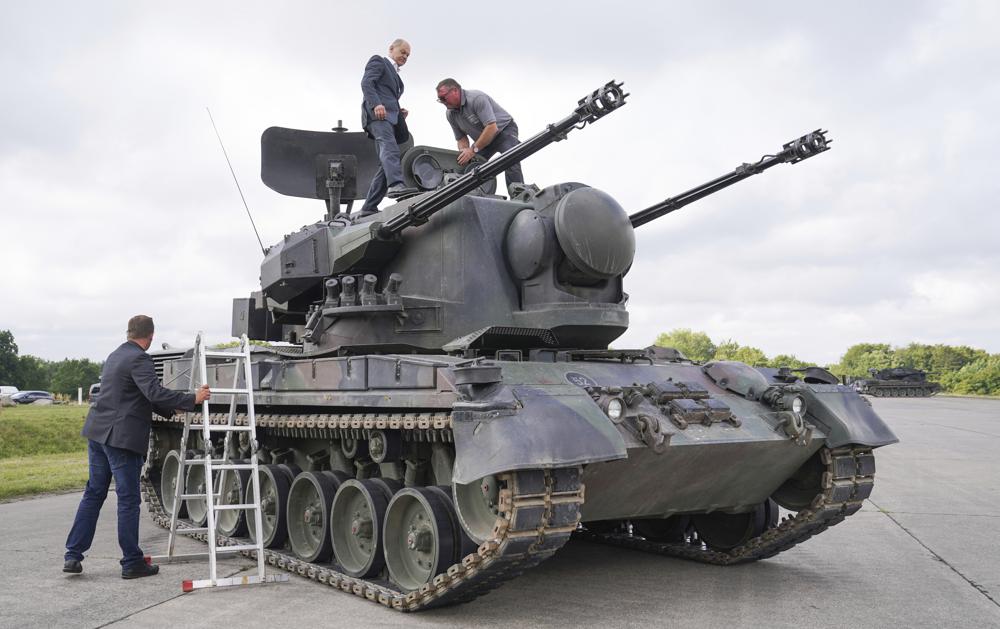 FILE - German Chancellor Olaf Scholz, top left, stands on top of a German Gepard anti-aircraft gun tank as he visits a training program for Ukrainian soldiers at a military training area in Putlos, Germany, Aug. 25, 2022.