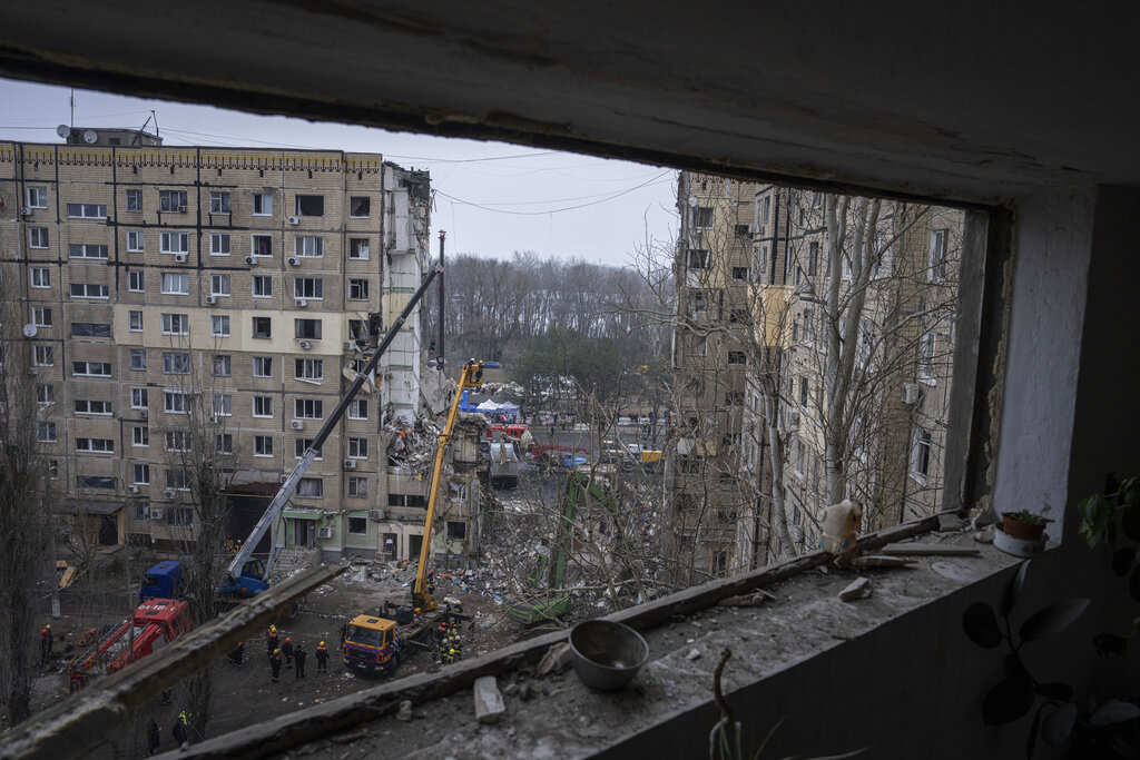 Rescue workers clear the rubble from an apartment building that was destroyed in a Russian rocket attack on a residential neighborhood in the southeastern city of Dnipro, Ukraine, Monday, Jan. 16, 2023. (AP Photo/Evgeniy Maloletka)