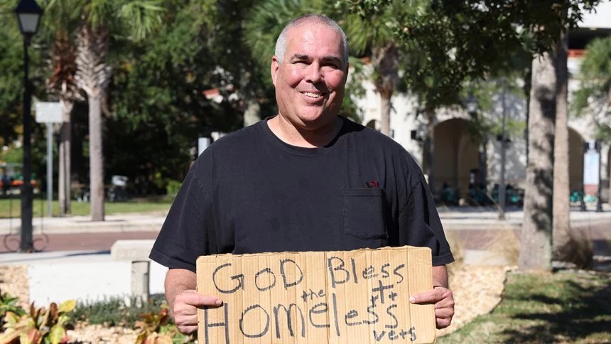 FIRE plaintiff Jeff Gray holds a sign that reads "God Bless the Homeless Vets"
